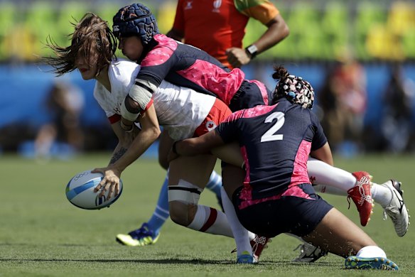 Canada's Natasha Watcham-Roy is tackled by Japan during the women's rugby sevens match.