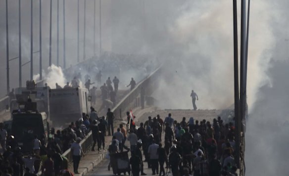 Members of the Muslim Brotherhood and supporters of ousted Egyptian President Mohamed Mursi flee from tear gas and rubber bullets fired by riot police during clashes, on a bridge leading to Rabba el Adwia Square where they are camping, in Cairo.