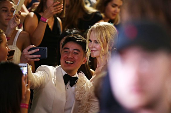 Nicole Kidman posing with fans on the red carpet.