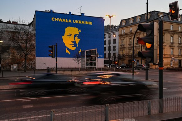 Cars drive past a recently painted mural in support of Ukraine, featuring President Volodymyr Zelenskyy, in Krakow, Poland. 
