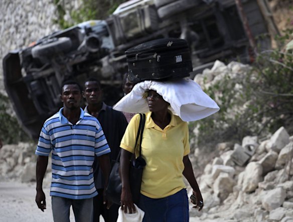 Homeless residents walks along a destroyed street.