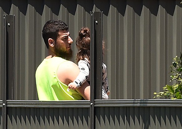 A file photo of Mehmet Biber carrying his daughter in the backyard of the family home in Merrylands, Sydney.