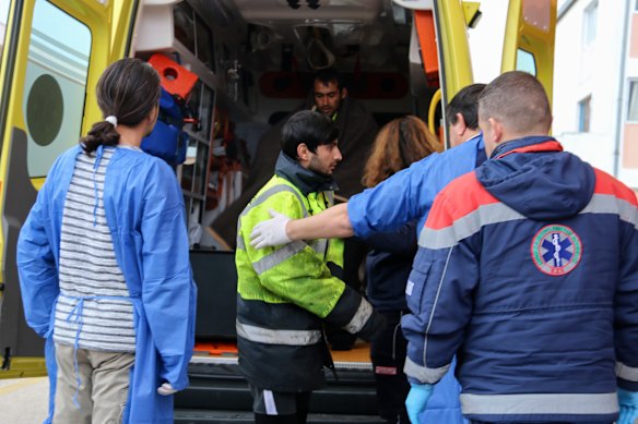 Medical staff transfer a survivor from an ambulance to hospital.