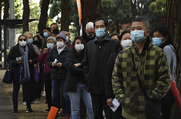 People queue on day two of the Sydney lockdown for COVID-19 vaccinations at the NSW Health Vaccination Centre at Olympic Park.
