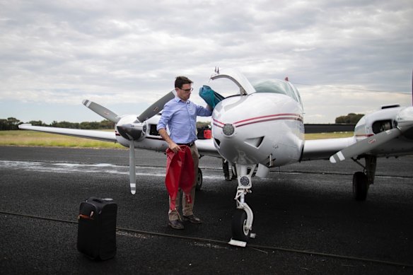 Minister for Agriculture and Water Resources David Littleproud unloads luggage from the plane after landing in Tambo, Queensland.
