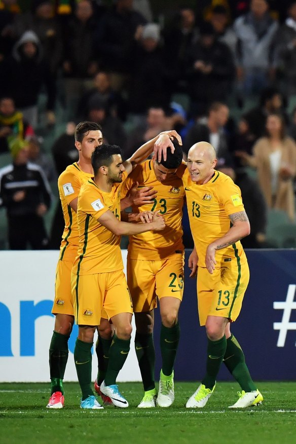 Tomi Juric, Aziz Behich and Aaron Mooy congratulate Tom Rogic after he scored the winner in the World Cup qualifier against Saudi Arabia.