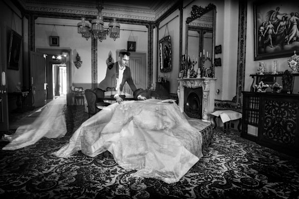 Adam Lindsay, Executive Director of Sydney Living Museums uncovering furniture which has been protected from dust and sunlight in the Drawing Room of Vaucluse House.