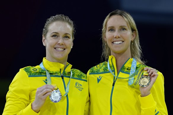 Silver medalist Holly Barratt of Australia, left, and gold medalist Emma McKeon, also of Australia pose with their medals on the podium of the Women's 50 meters butterfly final.
