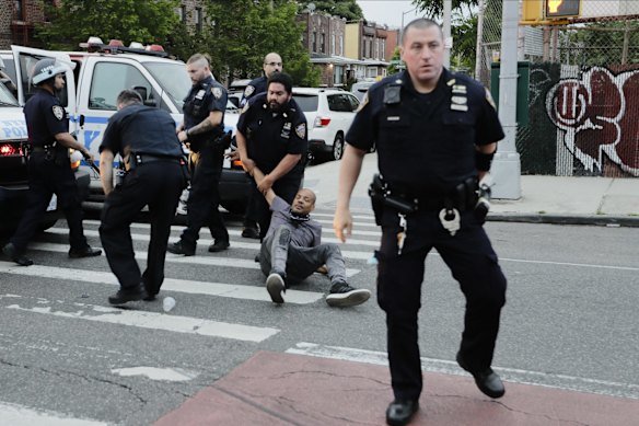 Police detain a man as protesters march during a solidarity rally for George Floyd, in the Brooklyn borough of New York. 