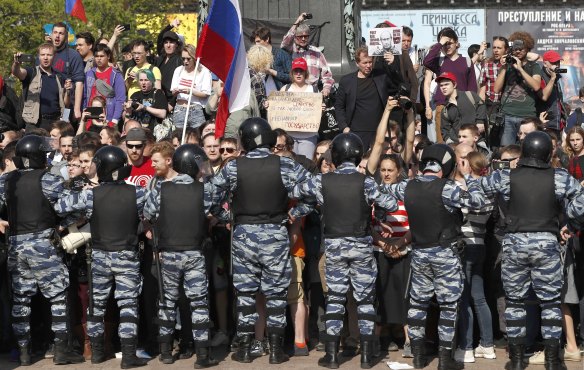 Russian police push protesters back. 