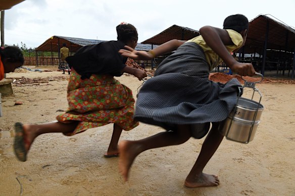 Avoiding guards and a long queue, Rohingya children run towards a Turkish aid agency food distribution site.