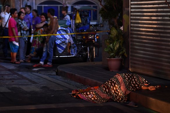 One of two people killed in a double shooting in the Manila suburb of Baclaran, near the airport, lies on a pavement. 