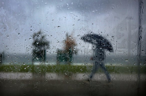 Taking cover under a brolley at Bondi.