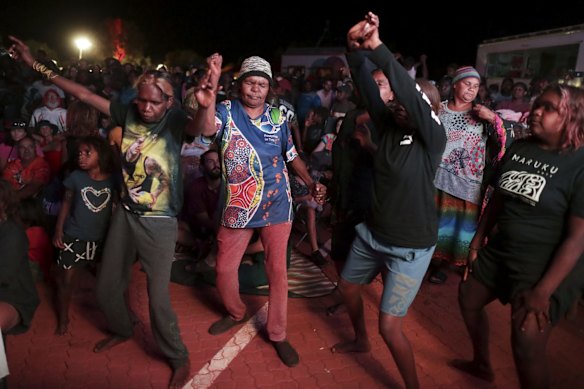 Women dance as they watch bands perform.