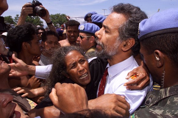 Xanana Gusmao pleads with demonstrators who disrupted the speech of Indonesian President Wahid in Dili East Timor as a wailing woman hugs the Independence leader. February 2000.