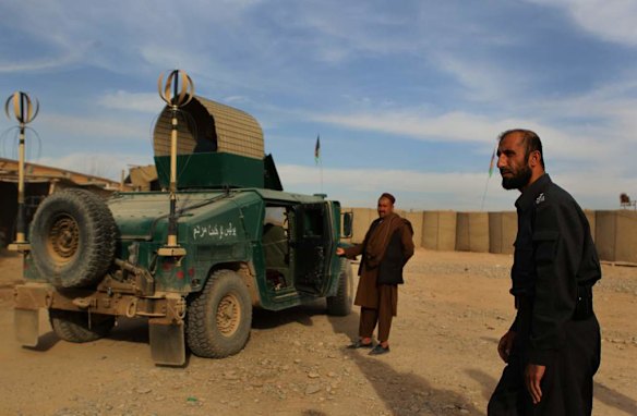 Uruzgan Police Chief, Matiullah Khan, right, walks towards his armoured humvee as his right hand man Mohammad Zai, left, holds his door open inside the Matiullah Khan compound in Tarin Kowt, Uruzgan, Afghanistan.