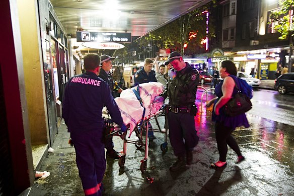 Ambulance officers tend to a patient in Kings Cross one year on from the murder of Thomas Kelly.
29th June 2013.
