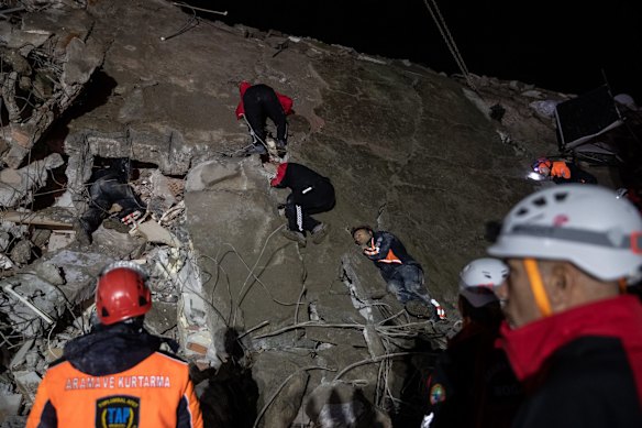 Rescue workers attend the scene of a collapsed building in Iskenderun, Turkey.
