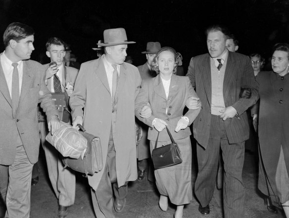 Evdokia Petrov being tightly gripped by a Russian bodyguard leading her across the tarmac at Mascot in 1954. 