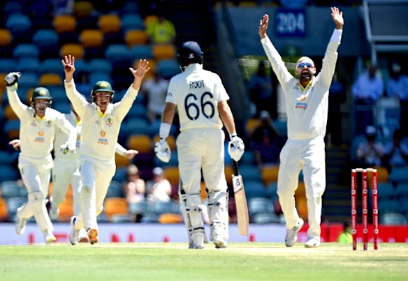 Nathan Lyon of Australia celebrates taking his 400th test wicket after dismissing David Malan of England for 82 runs during day four of the First Test Match in the Ashes series between Australia and England at The Gabba on December 11, 2021 in Brisbane, Australia.