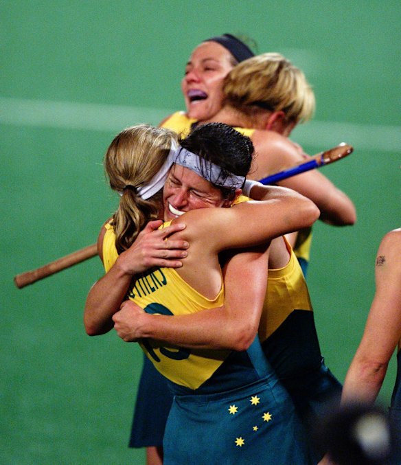 Australian team members hug each other after winning the gold medal. 