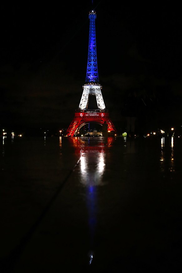The Eiffel Tower was cast in the red white and blue of the French tricolour in Paris on Tuesday.