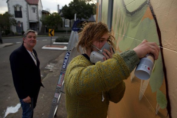 Street artist Birdhat and Victoria and Hobbs cafe owner Dale with a recently completed mural. Marrickville Council is pairing street artists with homeowners to make giant murals on their walls and deter graffiti artists.