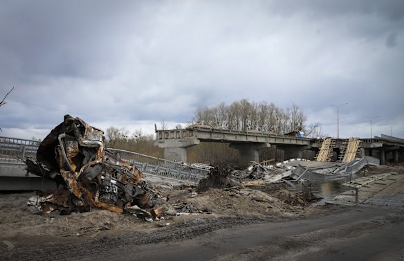 A car and a bridge destroyed by bombing in the village of Dymer, near Kyiv.