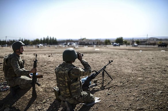 A Turkish soldier uses binoculars to check the Syrian border near the Mursitpinar border crossing on the Turkish-Syrian border in the southeastern town of Suruc, Sanliurfa province, on October 4, 2014. Photo by AFP