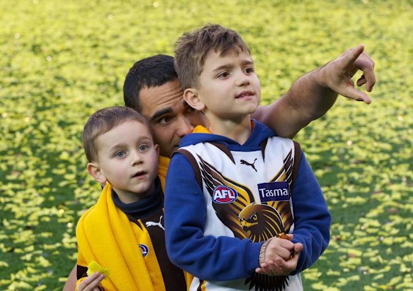 Shaun Burgoyne on the ground with his kids after the Hawthorn win.