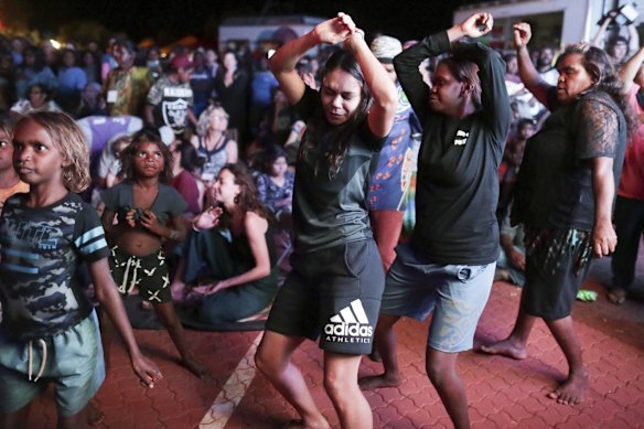 Women dance as they watch bands perform.