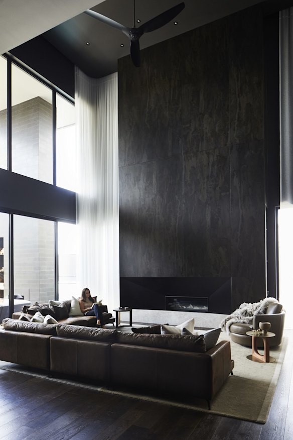 A soaring 7½-metre fireplace in the open-plan lounge, dining and kitchen space is finished in Dekton slabs. The leather sofas are by Boyd Blue.
