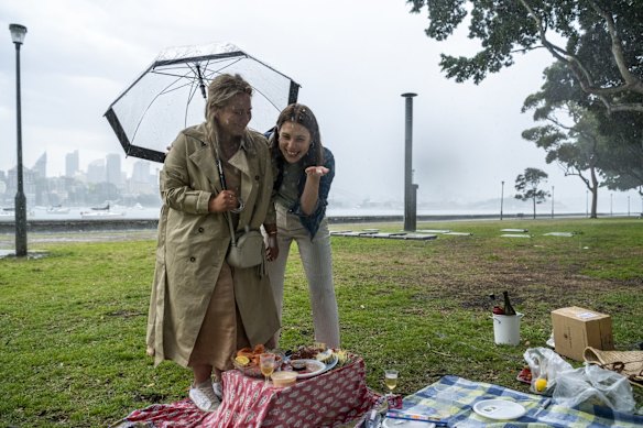 A picnic is disrupted due to heavy rain, at Rushcutters Bay.