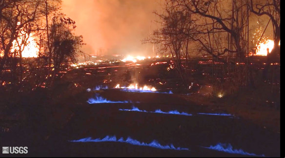 Blue flames of methane gas erupt through cracks on Kahukai Street in the Leilani Estates neighborhood of Pahoa on the island of Hawaii overnight on Wednesday.