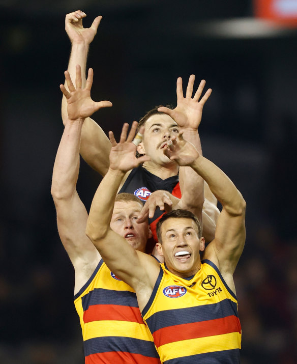 Essendon’s Sam Draper and Adelaide’s Tom Doedee leap for the ball.
