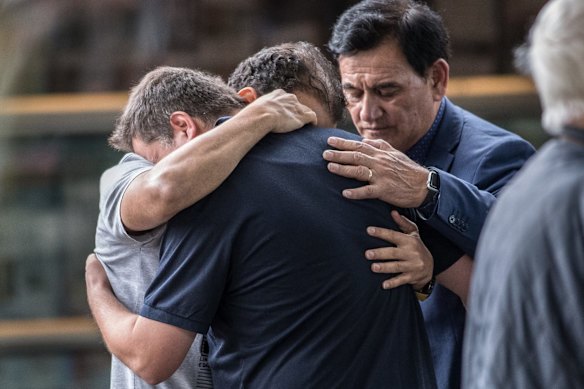 Members of the muslim community console each other at the Hagley College.