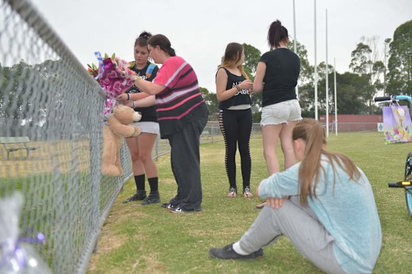 Friends arrive at the Tyabb oval to place flowers.