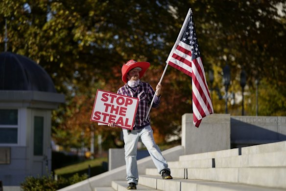 A demonstrator carries an American flag outside the Pennsylvania State Capitol.