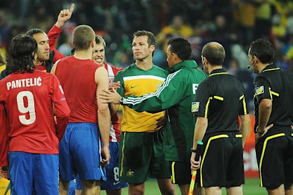 Serbian players surround the referee.