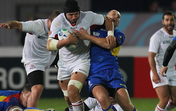 Dimitri Basilaia of Georgia is tackled by Marin Danut Dumbrava.