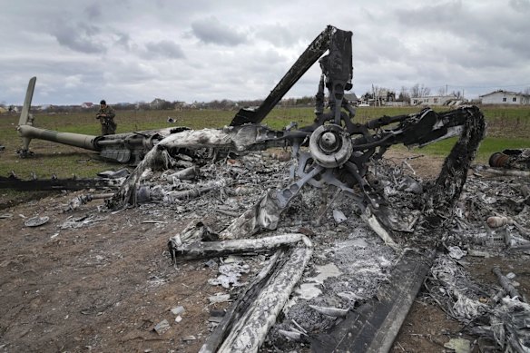 A Ukrainian sapper searches for unexploded explosives through the gutted remains of a Russian helicopter destroyed at the Antonov airport in Hostomel.