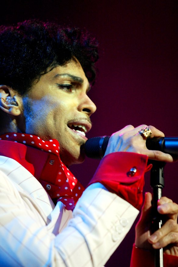 Prince reaches out to fans during tonight's performance at the Rod Laver Arena, Melbourne.  Picture by Viki Lascaris.  The Age.  Tuesday 21 October 2003.