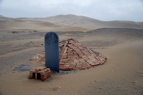Lonely graves sit on the edge of the dunes outside Dunhuang. Photo: Conrad Walters.