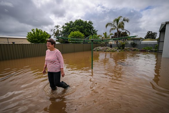 Glenys wades through the flood water.