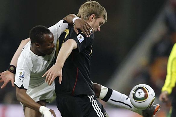 Dede Ayew of Ghana, left, and Per Mertesacker of Germany vie for the ball.