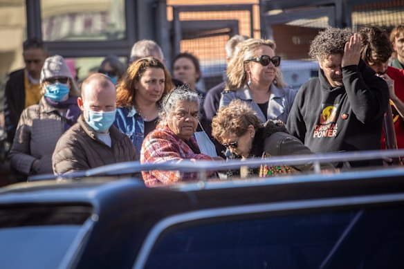 People gather as Archie Roach's body is escorted by the Southern Warriors Aboriginal Motorcycle Club outside the Aboriginal Health Service, Nicholson St in Fitzroy.
