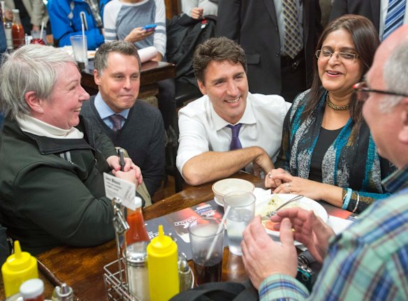 It's hard to be sad in a smoked meat restaurant as the PM demonstrates here in Quebec.
