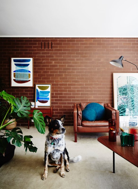 Walter sits by a coffee table designed by Alexander Girard for Knoll in 1948. The oil paintings to the left are by Hannah Nowlan and the glassware is from Open Room.