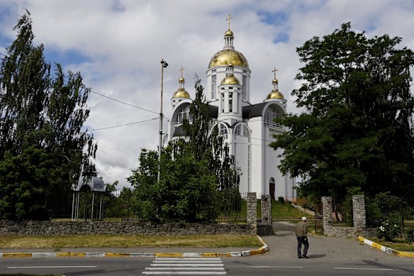 A man walks past the entrance to Bucha's St Andrew's church, the site of the mass grave of civilians killed by Russian soldiers when they occupied the town.