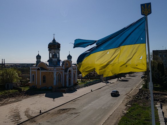 The damaged St Godmother's Cover Church next to a bullet-riddled Ukrainian national flag in Malyn. The communities north of Kyiv were square in the path of Russia's devastating but ultimately unsuccessful attempt to seize the Ukrainian capital with forces deployed from Belarus, a Russian ally.